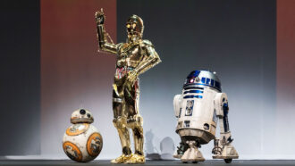 Three droids, BB-8, C-3PO and R2-D2 on a stage