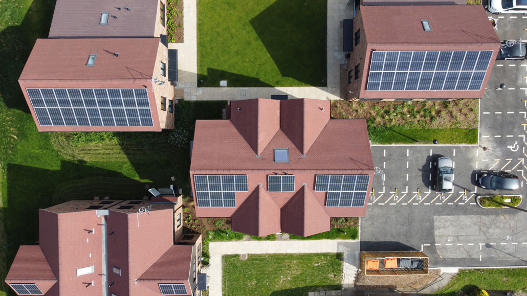 an aerial image showing solar panels on the roofs houses built close together