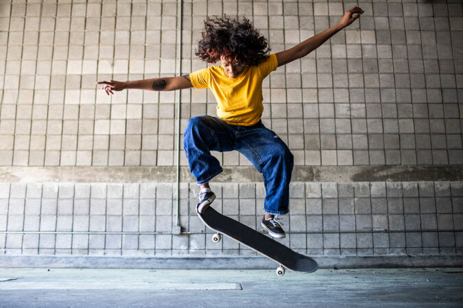 Woman does trick mid-air with a skateboard