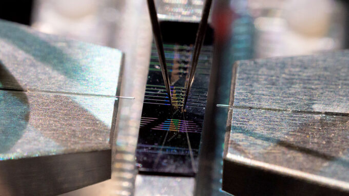 a macro photo of a the new computer chip, a black rectangular wafer with rainbow colored horizontal ridges