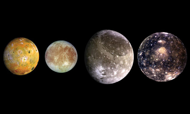 four pockmarked orbs of different sizes are in a row against a black background; the leftmost one (Io) is a splotchy orange-ish green; the second from right (Europa) is bluish-white with deep red scratches and patches; the second from right (Ganymede) is larger than the other two and silvery with white craters; the rightmost (Callisto) is slightly smaller than Ganymede and a deep blue with bright white spots