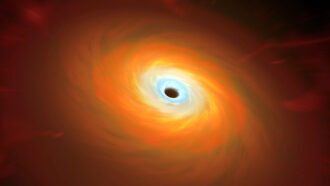 a black pit is surrounded by a reddish, orangish swirling disk