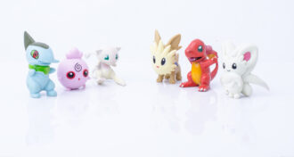 Six plastic Pokemon figurines lined up against a white background.