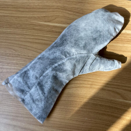 a dark mitten covered in a gauzy white material
