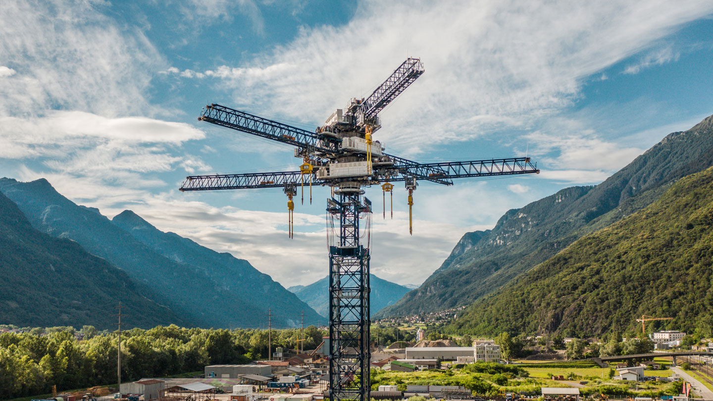 a huge crane-like structure rises into the sky in the valley of a mountain range