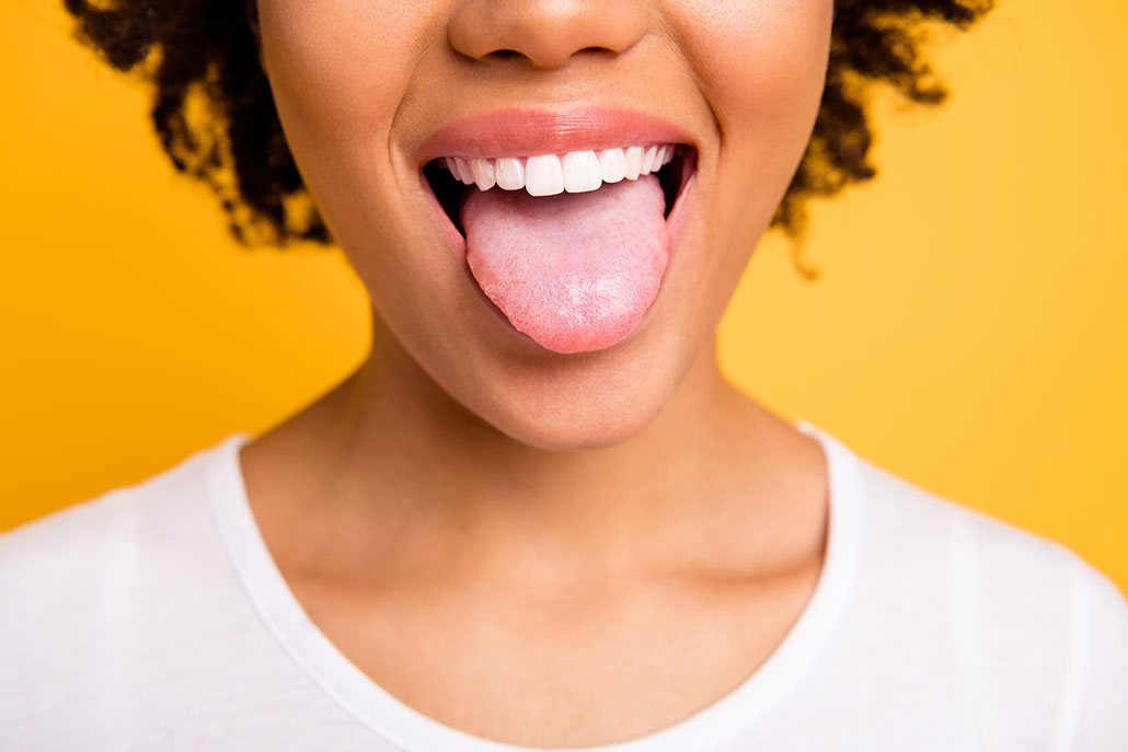 a nose down photo of a woamn with light brown skin sticking her tongue out at the viewer