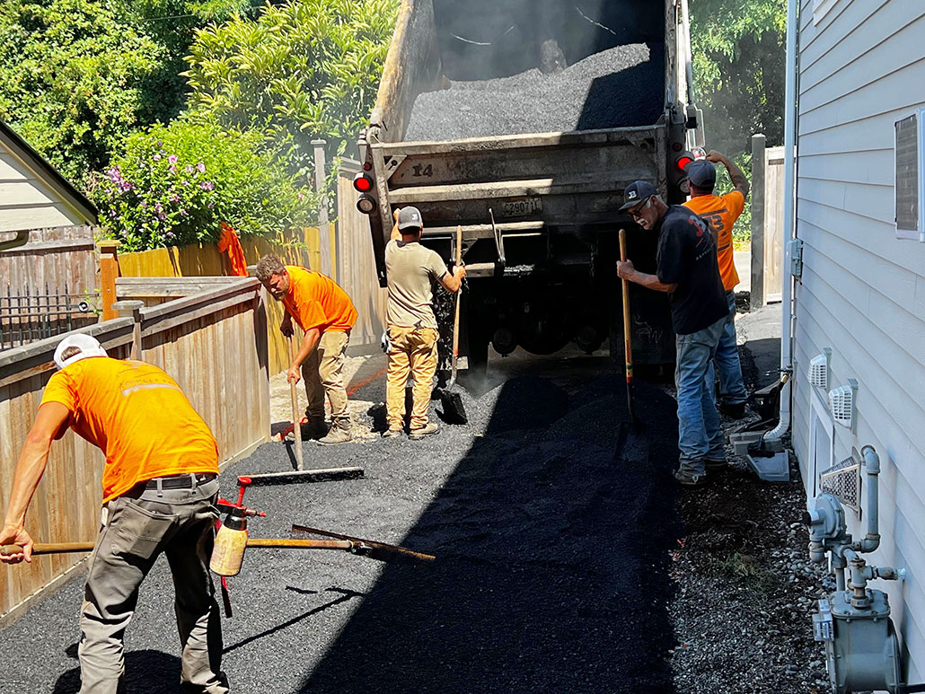 construction workers pouring an asphalt driveway