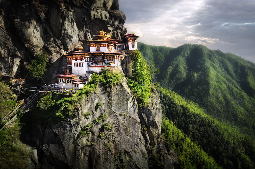 a scenic view of the Tiger Nest Monastery, a temple built into the Himalayan mountains
