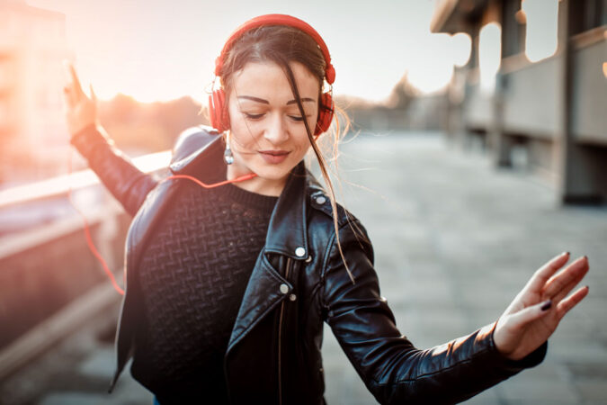 a girl listening to music on headhphones and dancing