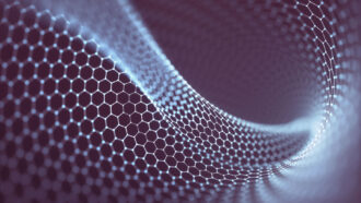 an illustration of graphene shows a net-like sheet of atoms connected in a honeycomb pattern