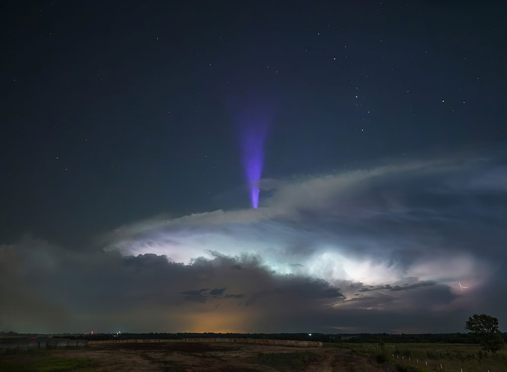 a funnel-shaped fountain of blue light erupts from the top of a storm cloud