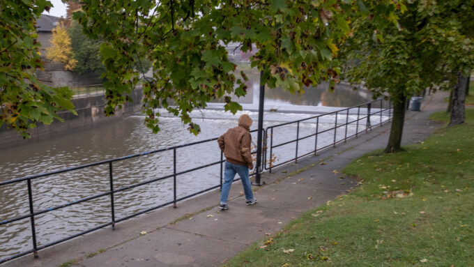 a photo of a person walking along the Flint River in downtown Flint Michigan