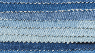 several pieces of denim dyed different shades of blue are fanned out on top of each other