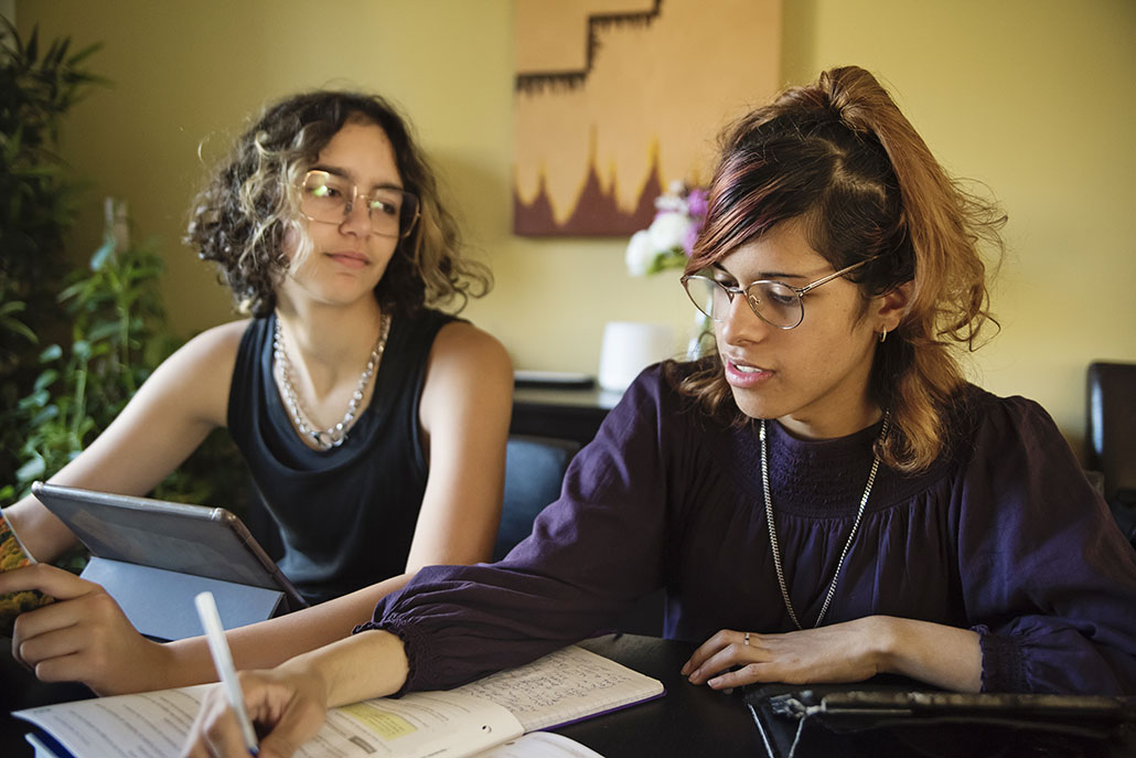 two friends sitting together to do homework