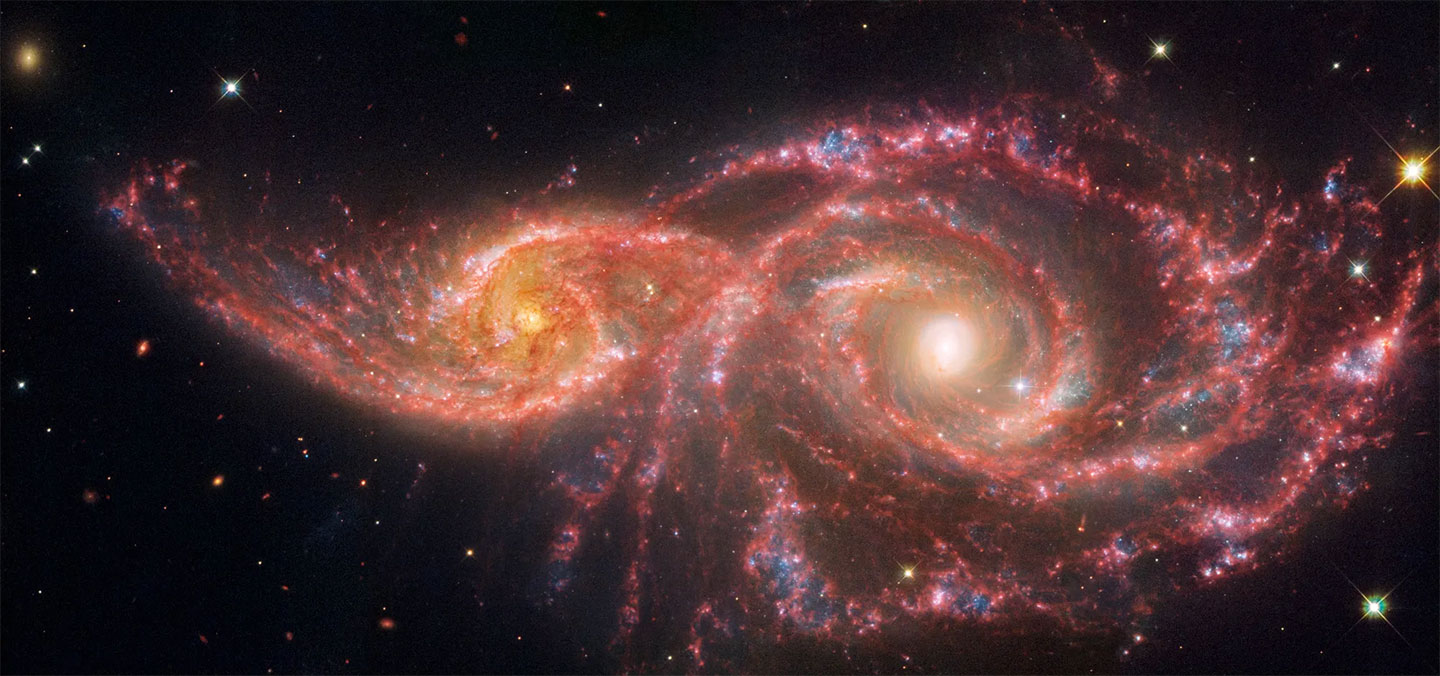 two spiral galaxies sail past each other in this telescopic image