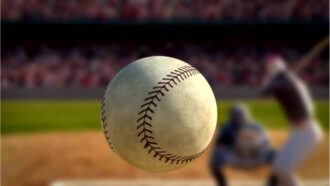a still image of a baseball flying through the air towards a batter