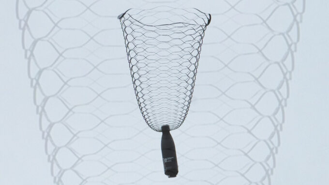 A water bottle dangles from a lacy, vase-shaped parachute.