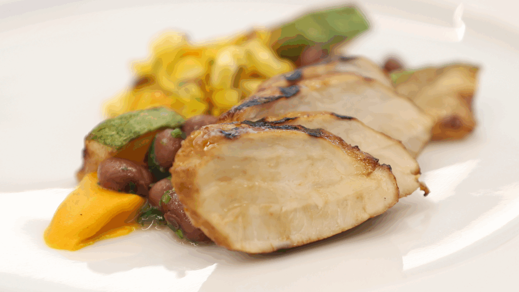 a plate holds a meal of lab-grown chicken with vegetables