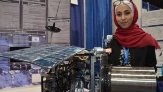 Dana Arabiyat, 15, of Amman, Jordan, designed a satellite (model shown) to collect and dispose of the space trash that threatens other satellites orbiting Earth.