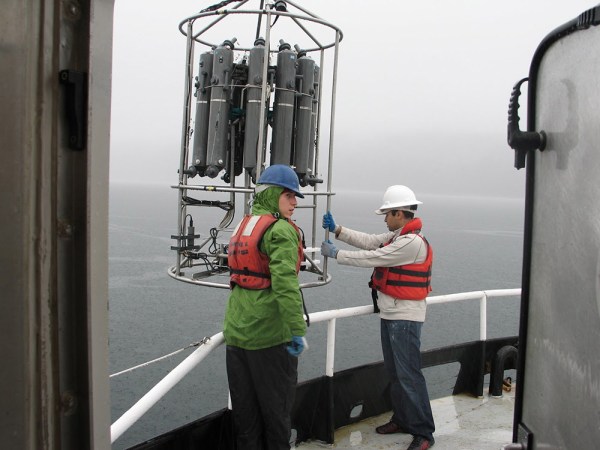 Scientists on a research ship prepare to lower an instrument, called a CTD rosette, into the ocean. The rosette, lowered on a cable, can sample water at different depths in the ocean, starting near the surface and going down thousands of feet. Water sampled this way allows scientists to discover microbes that grow deep down in the ocean. Credit: David Stahl (University of Washington)