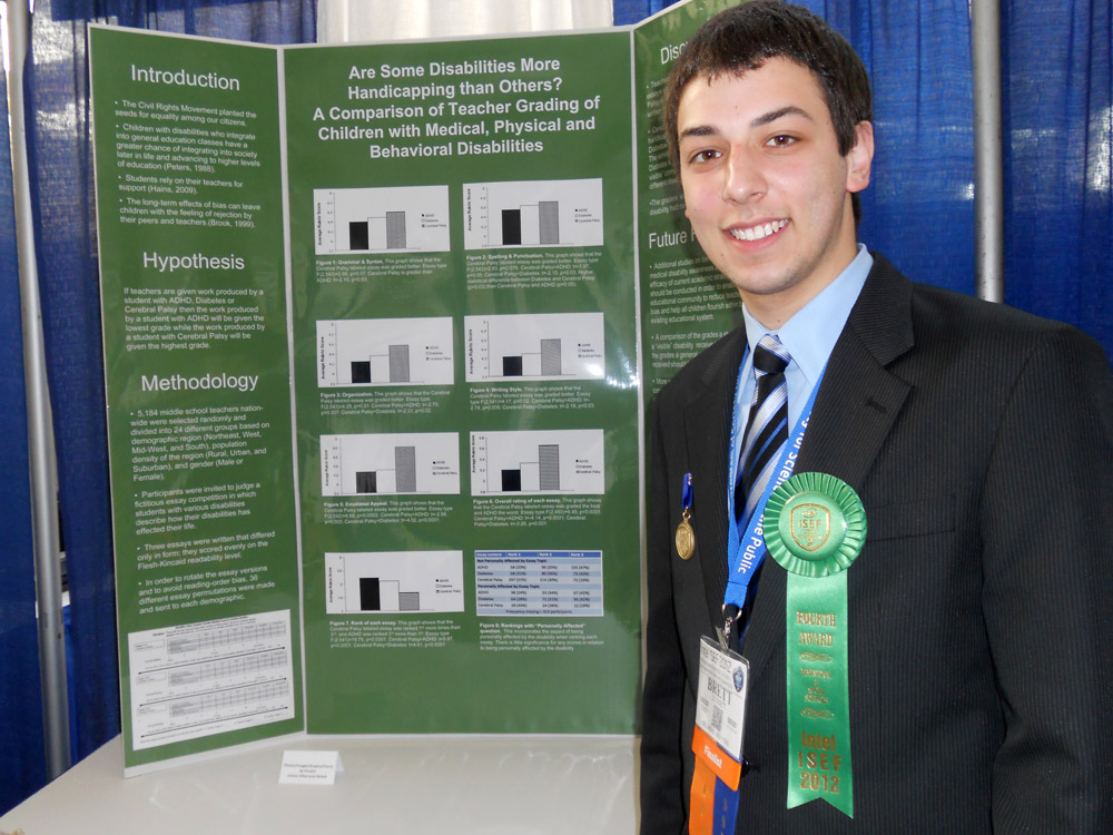 Brett Gossett poses in front of a poster