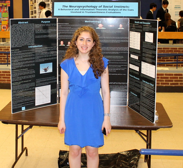 Claire Leibowicz poses in front of a poster