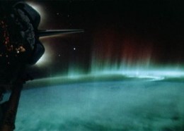 The red and green glowing lights in this picture are “airglow” in the Earth’s ionosphere. (This photo was taken from a space shuttle, visible at left.) The March tsunami that wreaked havoc on Japan produced similar atmospheric, glowing ripples.