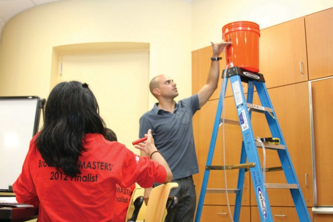 Julio Vargas, president of the Washington, D.C., chapter of Engineers Without Borders, speaks to members of the Red Team. He and his colleagues walked Broadcom MASTERS finalists through some of the math required in getting water from an elevated holding tank to homes. Credit: Jessica Kirsh (IML Photography) / SSP