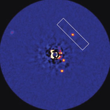 Bright dots depict the infrared radiation emitted by the four known planets circling the star HR 8799. The planet HR 8799c is in the rectangular box. Credit: Image courtesy of C. Marois/NRC-HIA, W.M. Kech Observatory
