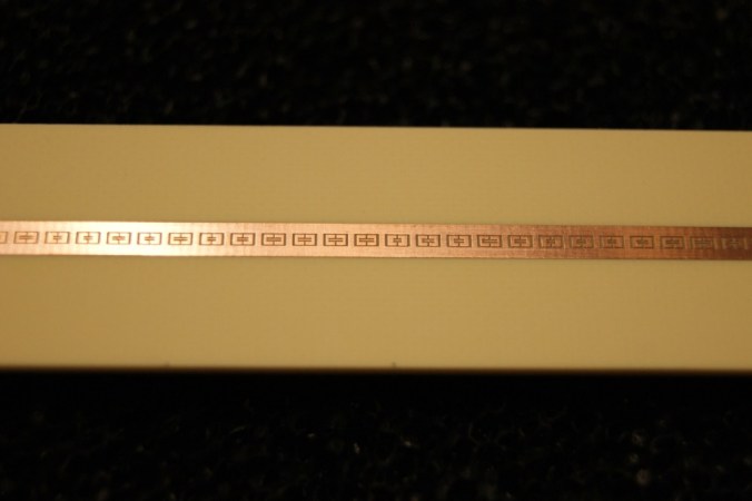 Tiny patterns cut into this narrow copper strip filter microwaves. This new, simple technology makes it possible to take digital pictures faster, with less computer time required. And it could be used to help make airport scanners smarter, faster and cheaper. Credit: J. Hunt/Duke