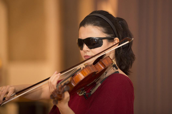 a person wearing dark glasses playing a violin
