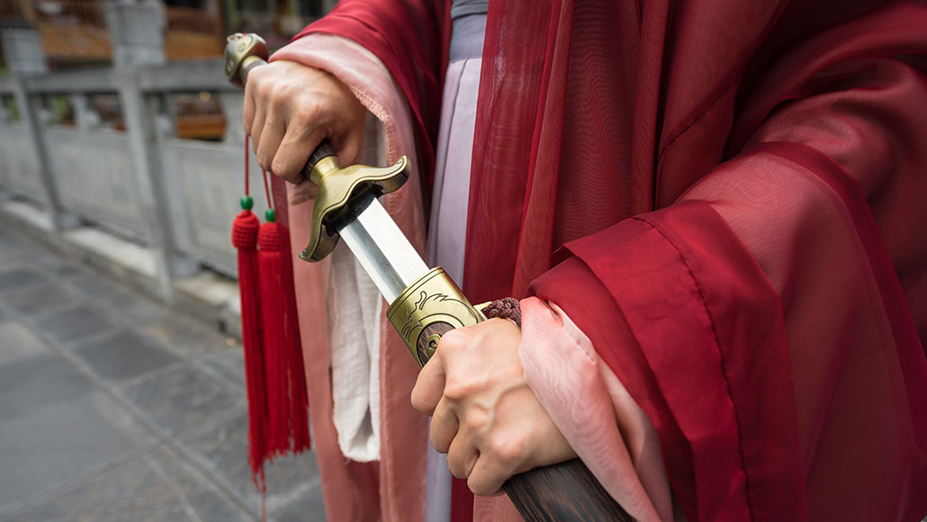 a photo of the hands of a Chinese warrior drawing a sword