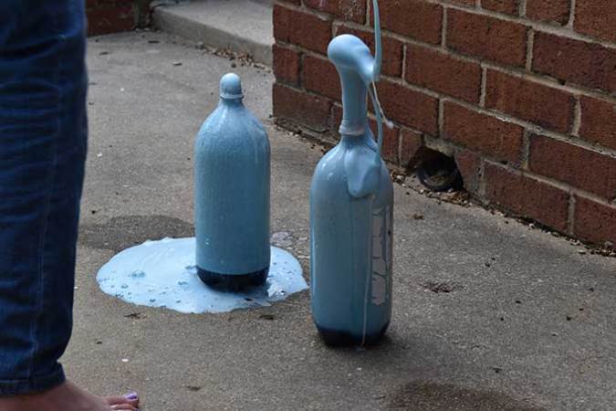 blue foam erupts from the 100 gram baking soda bottle volcanoes
