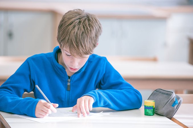 a student sitting at a desk and writing