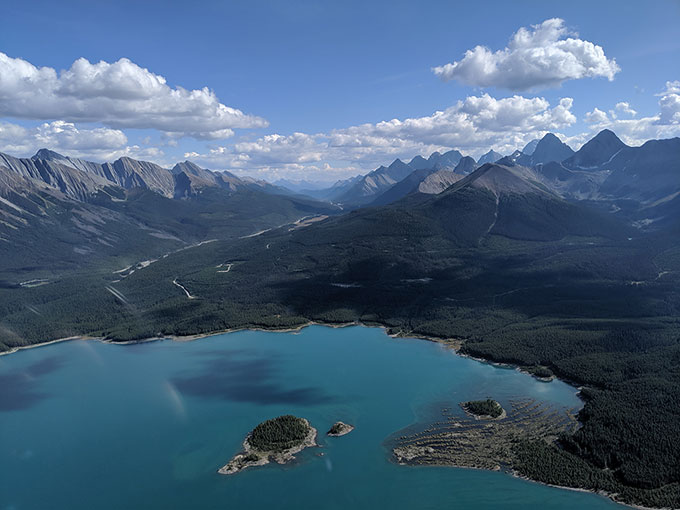 an aerial view of a pristine lake surrounded by mountains