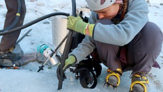 a photo of Ellery drilling into a glacier using steam