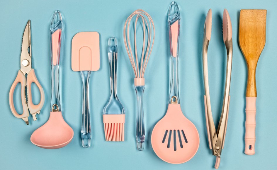 a row of spatulas, tongs, ladles and other kitchen tools with pink silicone pieces
