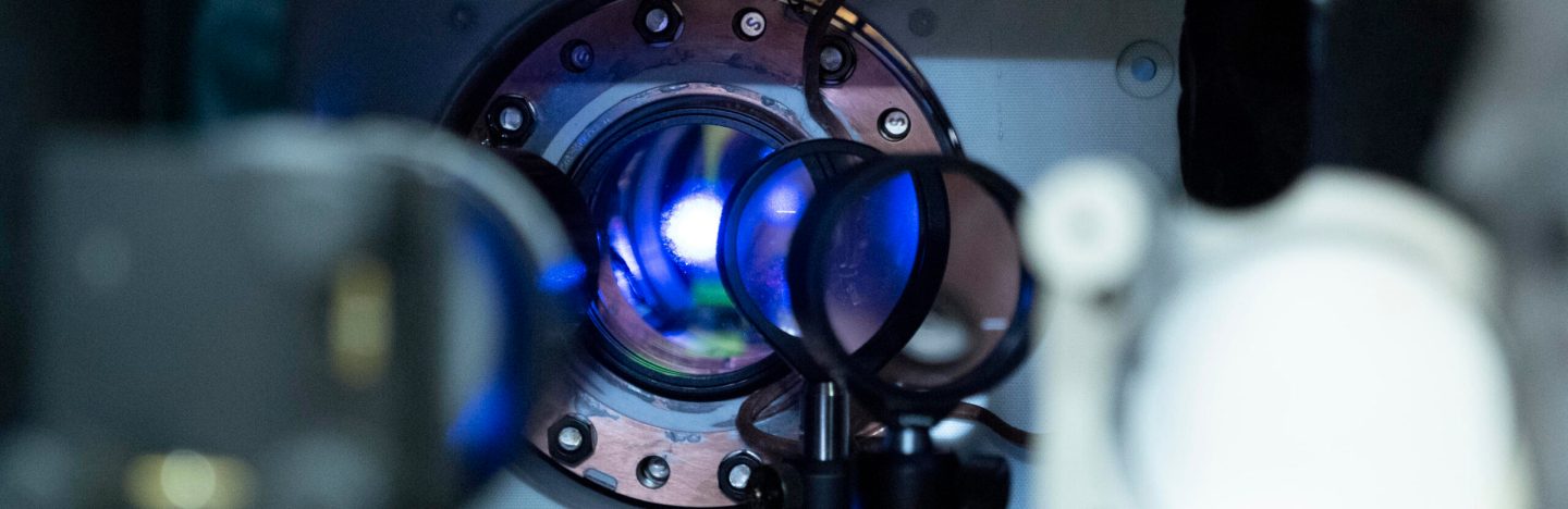 a closeup of machinery shows, through a lens, a bright glowing white ball