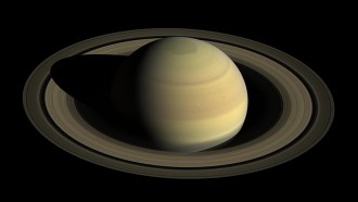 Saturn from an angle of roughly 45 degrees from the plane defined by its rings. The sunlight casts a shadow of the planet across its rings.