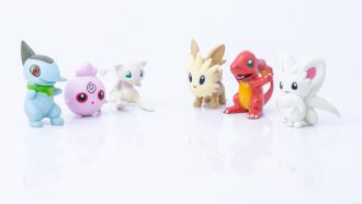 Six plastic Pokemon figurines lined up against a white background.