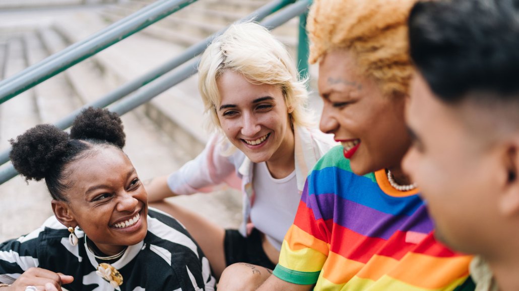 Lgbtqia+ friends talking sitting on a staircase outdoors