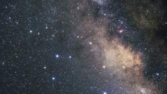 An image of the constellation Sagittarius shows a star-dotted expanse of space. There is a lone black hole (not visible) on the loose in the region.