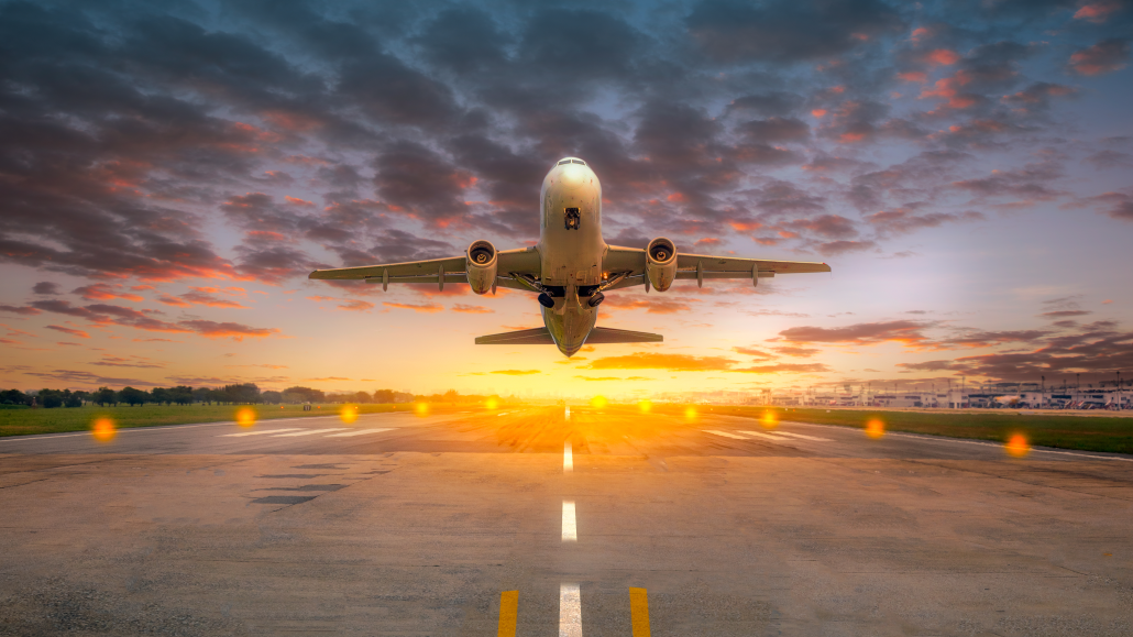 Airplane taking off from the airport runway in beautiful sunset light