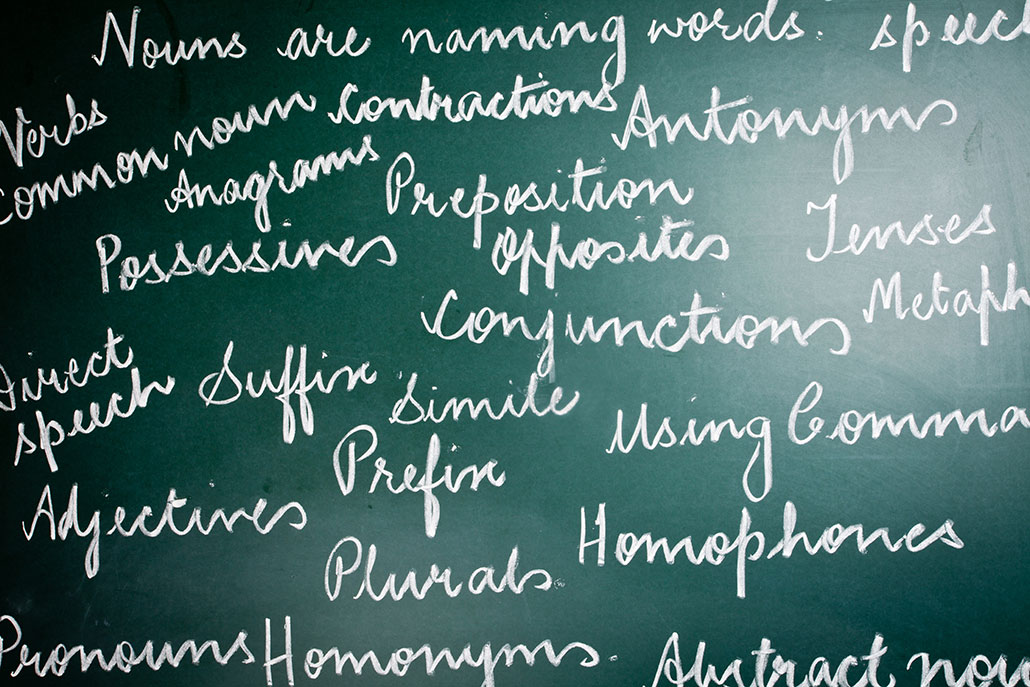 a photo of a chalkboard covered in cursive words related to grammar