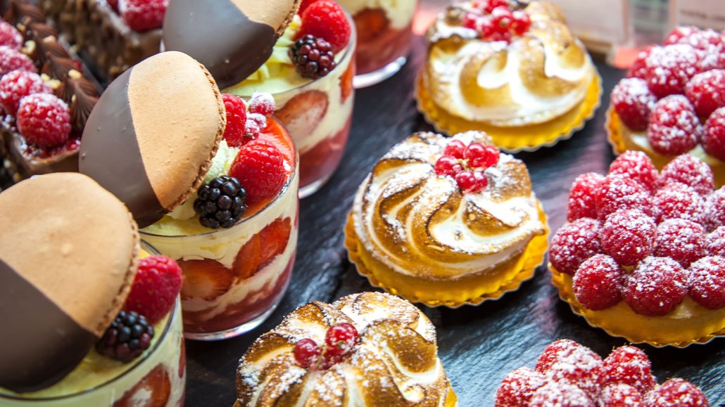 an assortment of French pastries with fruit, chocolate and creme in a display window