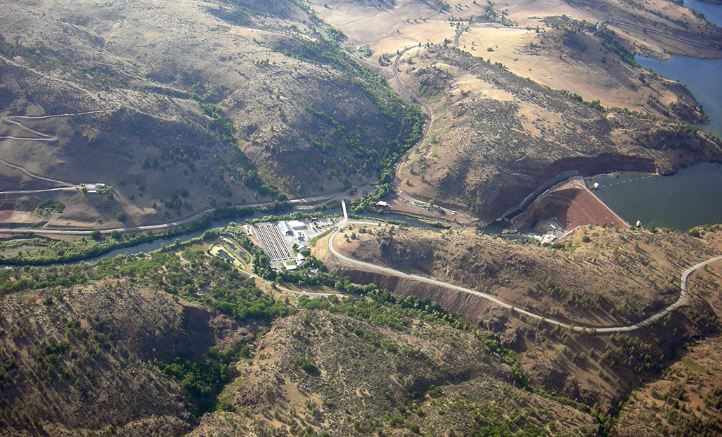 an aerial view showing the location of the Iron Gate Dam across the Klamath River, it's a large brown structure to the right of the image