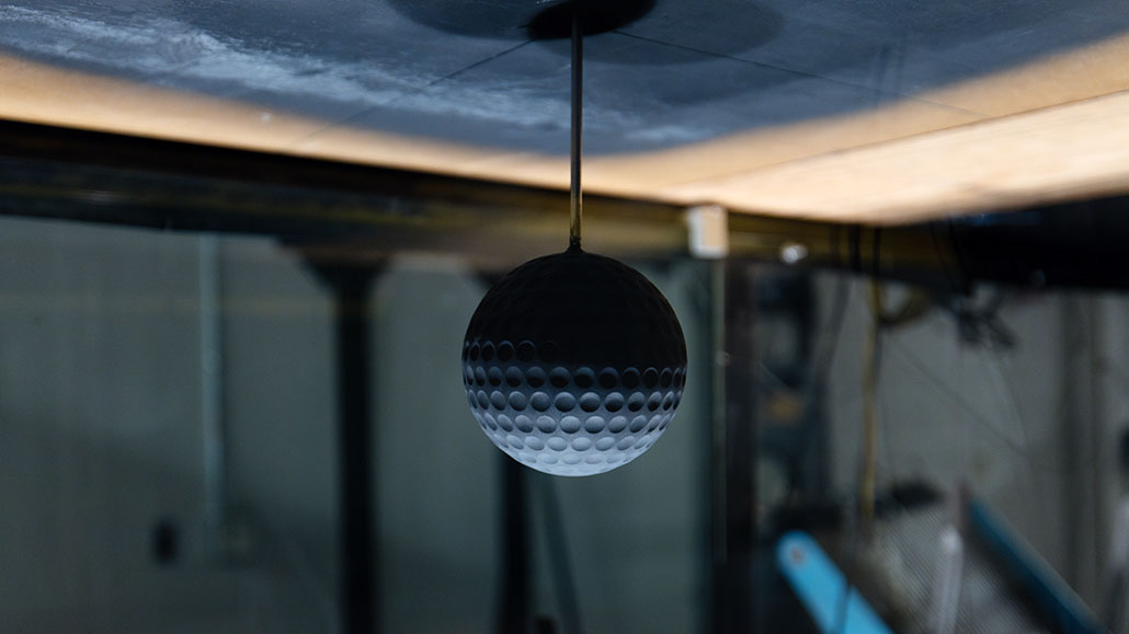 a grey 3d printed sphere is lit from the bottom to show the dimples 