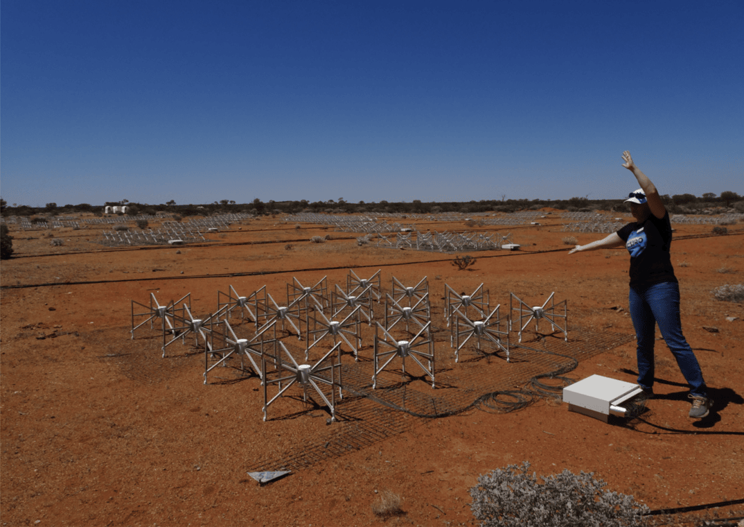 Chenoa Tremblay gestures to an array of spiderlike antennae stationed in the Outback. 