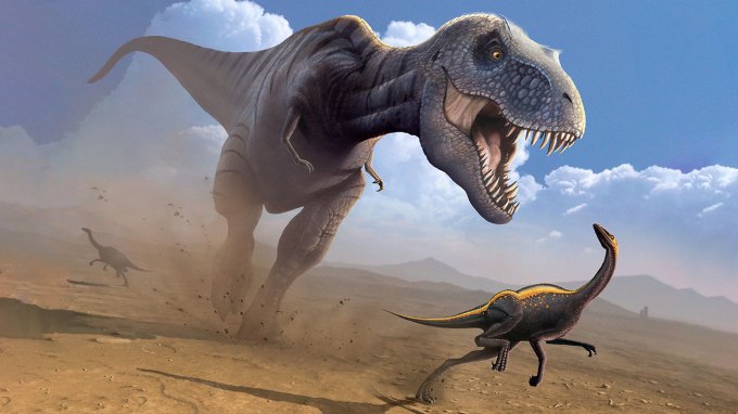 A T.rex chases a small dinosaur across a muddy flat.