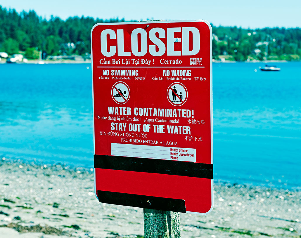 a sign explaining that the water at this beach is contaminated